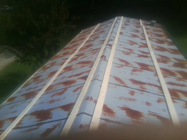 Rusted metal roof panels with new wood purlins before replacement — Storm Damage Roof Repair in Crawford by Roofing Brothers